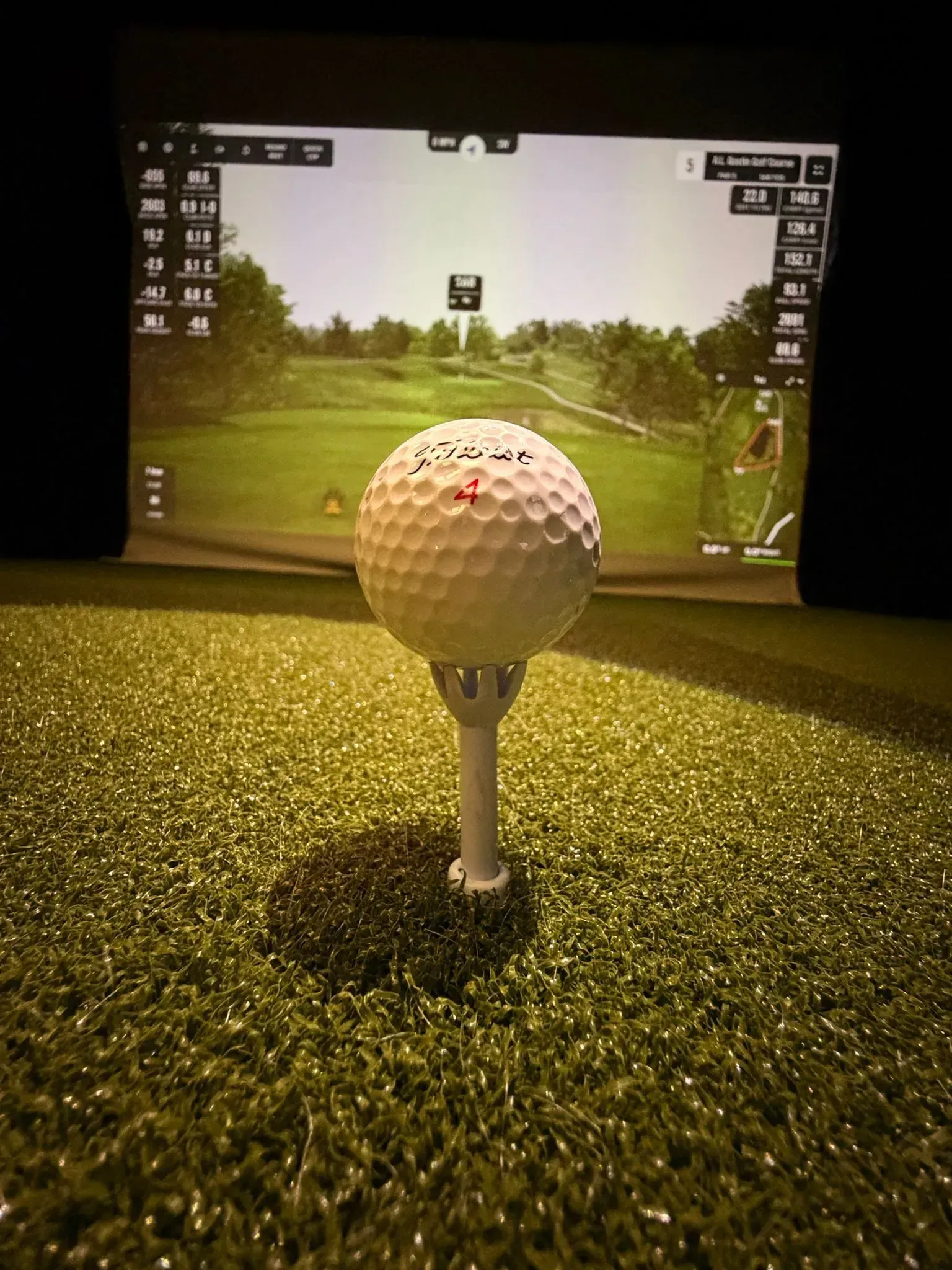 Golf ball teed up in front of the simulator screen at Virtual Fairways