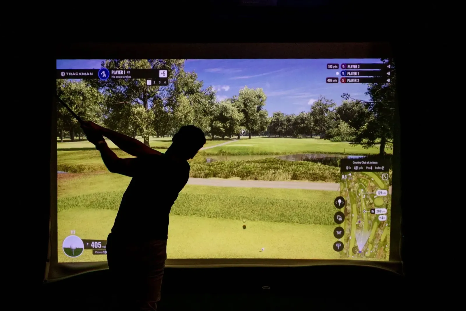 Long-exposure shot of a golfer mid-swing at a Virtual Fairways simulator bay