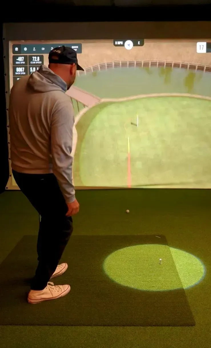 A golfer steadying themselves before taking a shot at Virtual Fairways